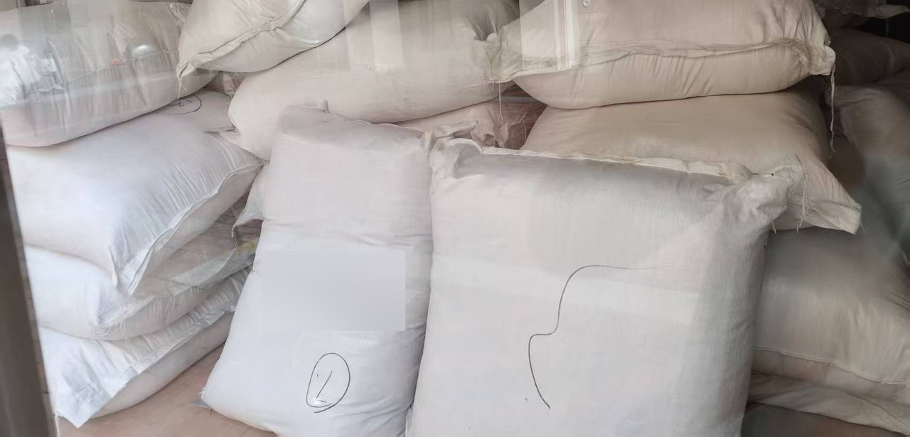 Bulk-packed goods in white sacks, with shipment marks obscured